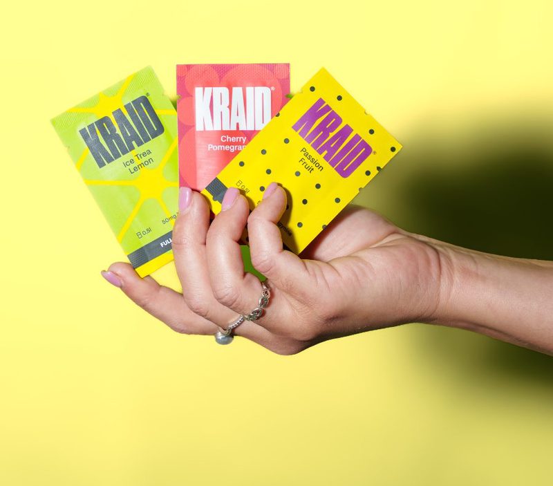 Eine Hand hält drei KRAID Sachets: Ice Trea Lemon, Cherry Pomegranate und Passion Fruit